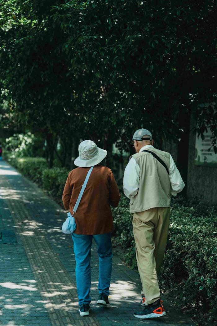 Older adults walking together in a Chinese garden setting